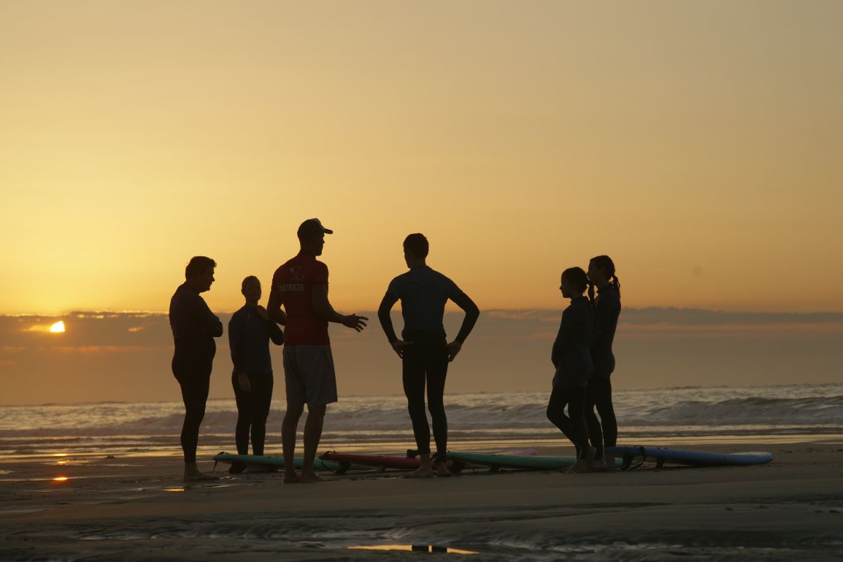 curso de surf al atardecer